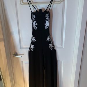 Form fitting spaghetti strap black romper w/ floral print & bow in back, Size S